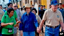 In this photo taken November 21, 2009 released by Habitat for Humanity, former U.S. President Jimmy Carter, right, holds the hand of his wife Rosalynn as they visit the Damnak Thom village where Habitat for Humanity volunteers built 21 houses, file photo. 