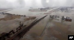 This aerial photo shows flooding along the Missouri River in Pacific Junction, Iowa, March 19, 2019. The U.S. Army Corps of Engineers says rivers breached at least a dozen levees in Nebraska, Iowa and Missouri.