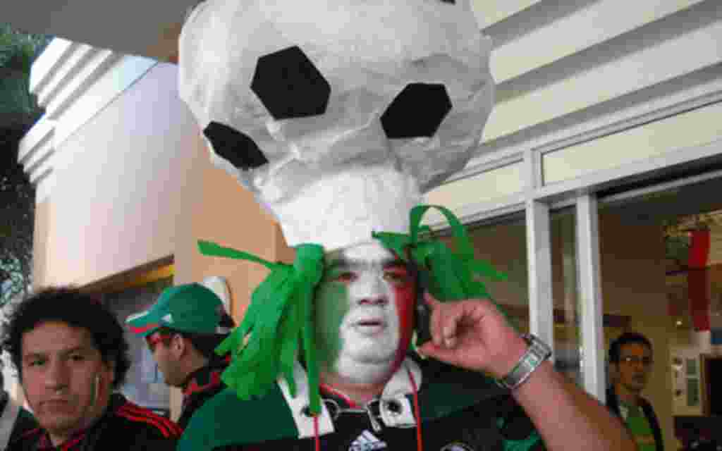 Mexicano con un balón de fútbol de sombrero, minutos antes del primer partido de su selección.