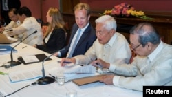 Representative of the Philippine government Jesus Dureza (R), Norwegian Foreign Minister Boerge Brende (C) and representative of National Democratic Front (NDF) Luis Jalandoni (2-R) are seen after signing an indefinite cease-fire agreement, in Oslo, Norwa