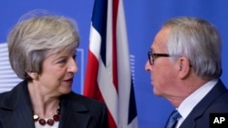 European Commission President Jean-Claude Juncker, right, greets British Prime Minister Theresa May at EU headquarters in Brussels, Wednesday, Nov. 21, 2018. 