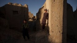 Afghan children stand among the ruins of houses destroyed by war in Salar village, Wardak province, Afghanistan, Oct. 12, 2021.