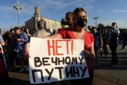 A woman holds a placard reading "No to an eternal Putin" as she protests amendments to Russia's Constitution, on Pushkin Square in downtown Moscow, July 1, 2020.