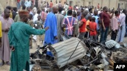 People look at the damage on March 2, 2014, after two explosions struck Nigeria's restless northeastern city of Maiduguri, a stronghold of Boko Haram Islamists.