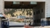 FILE - A road sign that reads "Welcome to Bab al-Hawa crossing" is seen at Bab al-Hawa crossing at the Syrian-Turkish border, in Idlib governorate, Syria, June 10, 2021. 