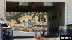 FILE - A road sign that reads "Welcome to Bab al-Hawa crossing" is seen at Bab al-Hawa crossing at the Syrian-Turkish border, in Idlib governorate, Syria, June 10, 2021. 