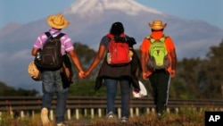 Central American migrants begin their morning trek facing Pico de Orizaba volcano as part of a thousands-strong caravan hoping to reach the U.S. border, upon departure from Cordoba, Veracruz state, Mexico, Nov. 5, 2018.