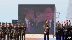 Gambar Presiden Obama dan Presiden Vladimir Putin pada layar ketika keduanya menghadiri peringatan D-Day di Perancis, 6/6/2014