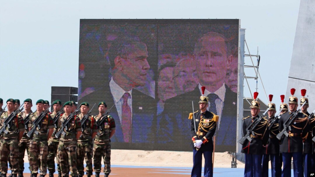 Gambar Presiden Obama dan Presiden Vladimir Putin pada layar ketika keduanya menghadiri peringatan D-Day di Perancis, 6/6/2014