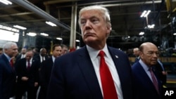 FILE - President Donald Trump pauses as he talks to media before signing an Executive Order on the Establishment of Office of Trade and Manufacturing Policy at The AMES Companies, Inc., in Harrisburg, Pa.