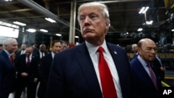 FILE - President Donald Trump pauses as he talks to media before signing an Executive Order on the Establishment of Office of Trade and Manufacturing Policy at The AMES Companies, Inc., in Harrisburg, Pennsylvania.