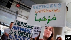 Protestas en la terminal internacional de Tom Bradley en el aeropuerto internacional de Los Ángeles. Una mujer sostiene un letrero que dice "bienvenidos" en inglés y árabe como manifestantes que se oponen a las órdenes ejecutivas del presidente Donald Trump que prohíben la entrada a Estados Unidos por musulmanes de siete países.