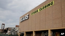  In this July 8, 2017, file photo people walk into a Sears store slated for closing that is next to a mall that is being torn down in Overland Park, Kan. Sears has filed for Chapter 11 bankruptcy protection Monday, Oct. 15, 2018.
