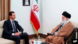 FILE - In this photo released by an official website of the office of Supreme Leader Ayatollah Ali Khamenei, right, Khamenei speaks with Syrian President Bashar al-Assad in Tehran, Iran, on Feb. 25, 2019. Analysts say Assad's exit from Syria weakens Iran regionally.