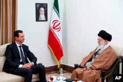 FILE - In this photo released by an official website of the office of the Iranian supreme leader, Supreme Leader Ayatollah Ali Khamenei, right, speaks with Syrian President Bashar al-Assad during their meeting in Tehran, Iran, Feb. 25, 2019.