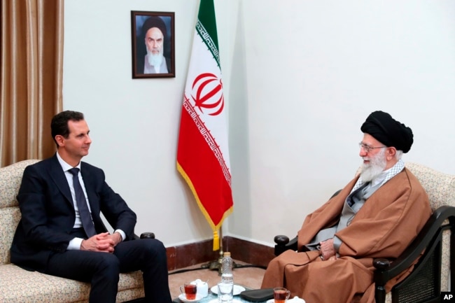DOSSIER - Sur cette photo publiée par un site officiel du bureau du guide suprême iranien, le Guide suprême, l’ayatollah Ali Khamenei, à droite, s’entretenant avec le président syrien Bashar al-Assad lors de leur réunion à Téhéran, en Iran, le 25 février 2019.