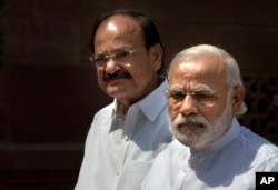Indian PM Narendra Modi, right, talks to media upon his arrival at the parliament house as Venkaiah Naidu stands along in New Delhi, India, April 25, 2016.