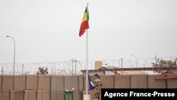 FILE - The Malian flag is hoisted during the handover ceremony of the Barkhane military base from the French to the Malian army in Timbuktu, Dec. 14, 2021.