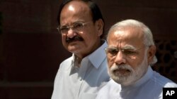 Indian PM Narendra Modi, right, talks to media upon his arrival at the parliament house as Venkaiah Naidu stands along in New Delhi, India, April 25, 2016.