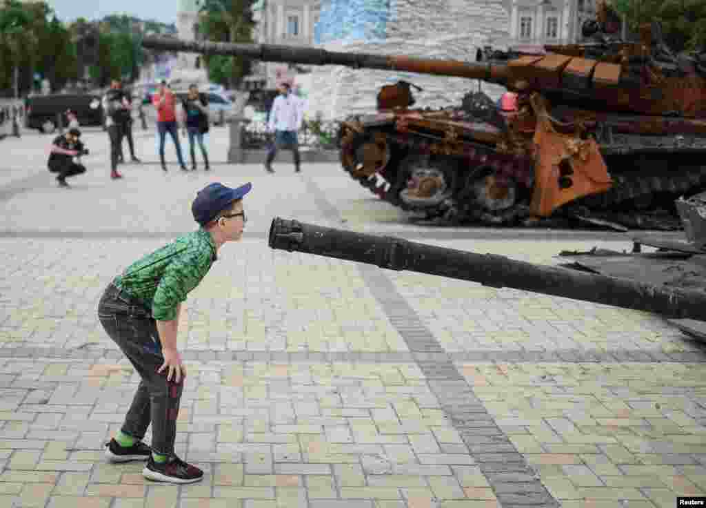 Un niño observa un tanque de guerra ruso destruido en una exposición de vehículos militares rusos en el centro de Kiev, Ucrania, el 21 de mayo de 2002.&nbsp;