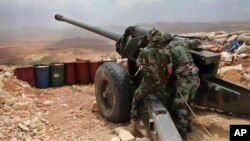 FILE -- Lebanese army soldiers work on a 130mm howitzer cannon, pointed at areas controlled by Islamic State group militants near Arsal, in northeast Lebanon, June 19, 2016.