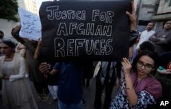 Sebuah kelompok sosial, Aurat March, menunjukkan poster bertuliskan dukungan untuk pengungsi Afghanistan dalam demonstrasi di Karachi, Pakistan, Minggu, 29 Oktober 2023. (Foto: Fareed Khan/AP Photo)