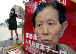 FILE - a newspaper stall features a photo of Dr. Jiang Yanyong in Beijing, China, June 5, 2003. Dr. Jiang told the media that more than 100 SARS patients were being treated in a few military hospitals alone and that many had died.