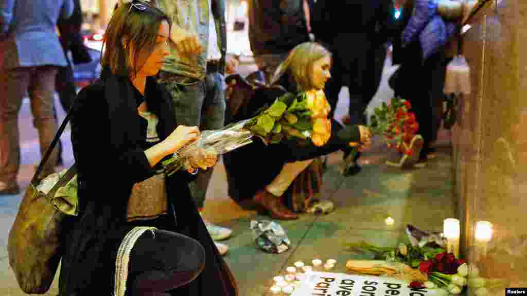 People place flowers at a makeshift memorial to pay tribute to the victims of the terror attack in Paris outside the Consulate General of France in San Francisco, California, Nov. 13, 2015.