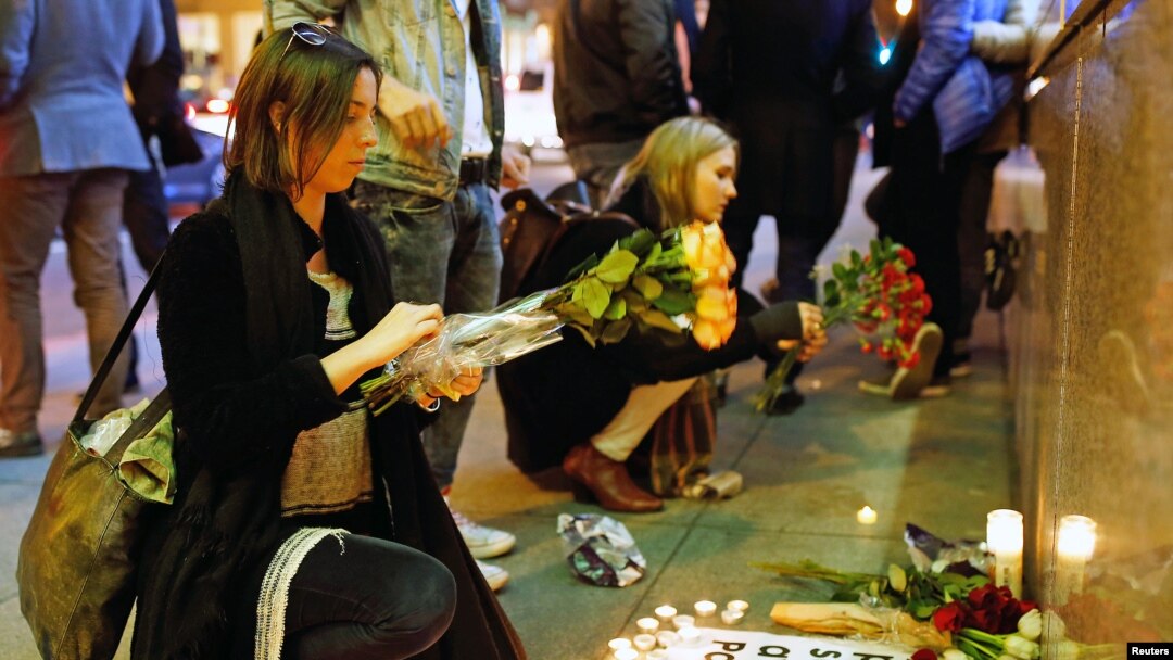People place flowers at a makeshift memorial to pay tribute to the victims of the terror attack in Paris outside the Consulate General of France in San Francisco, California, Nov. 13, 2015.