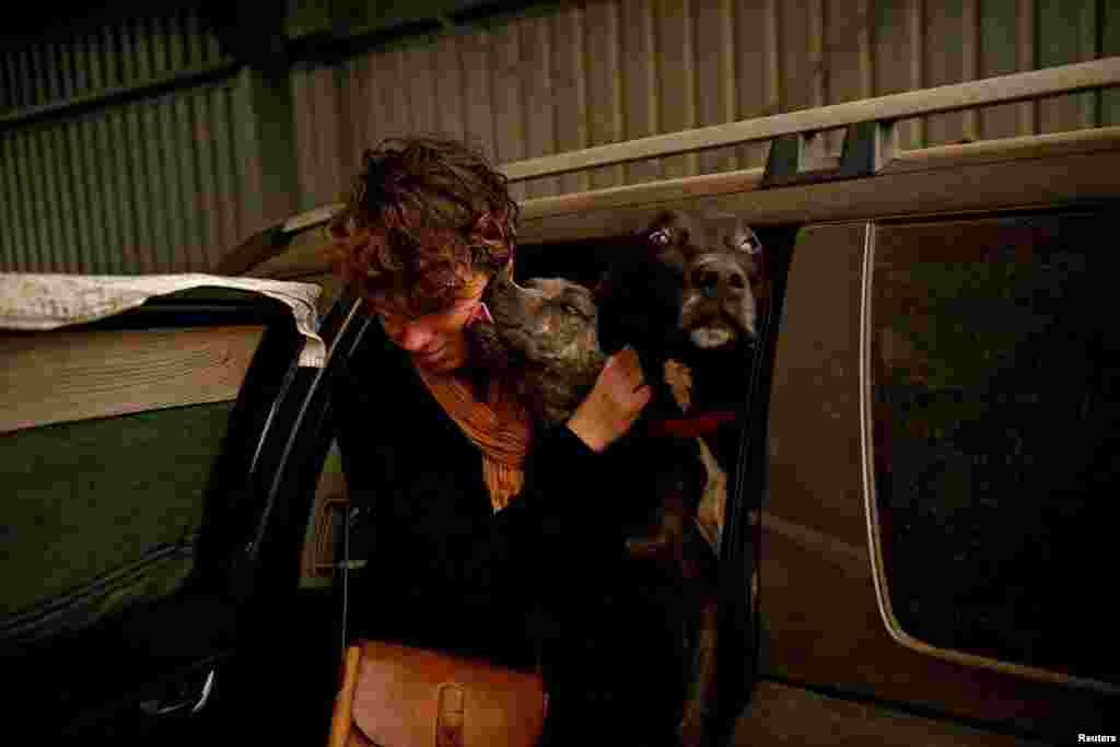 Bernadette Foster, a Dignams Creek resident, is seen with her pet dogs at the evacuation center in Cobargo, as bushfires continue in New South Wales, Australia.