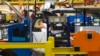 FILE - Production line workers fit parts to a Jeep Cherokee on the line at the upgraded North section of the Chrysler Toledo Assembly Complex, July 18, 2013.