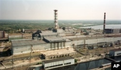 FILE - In this July 23, 1998 file photo, a chimney towers over the sarcophagus that covers the destroyed Reactor No.4 at the Chernobyl nuclear power plant.