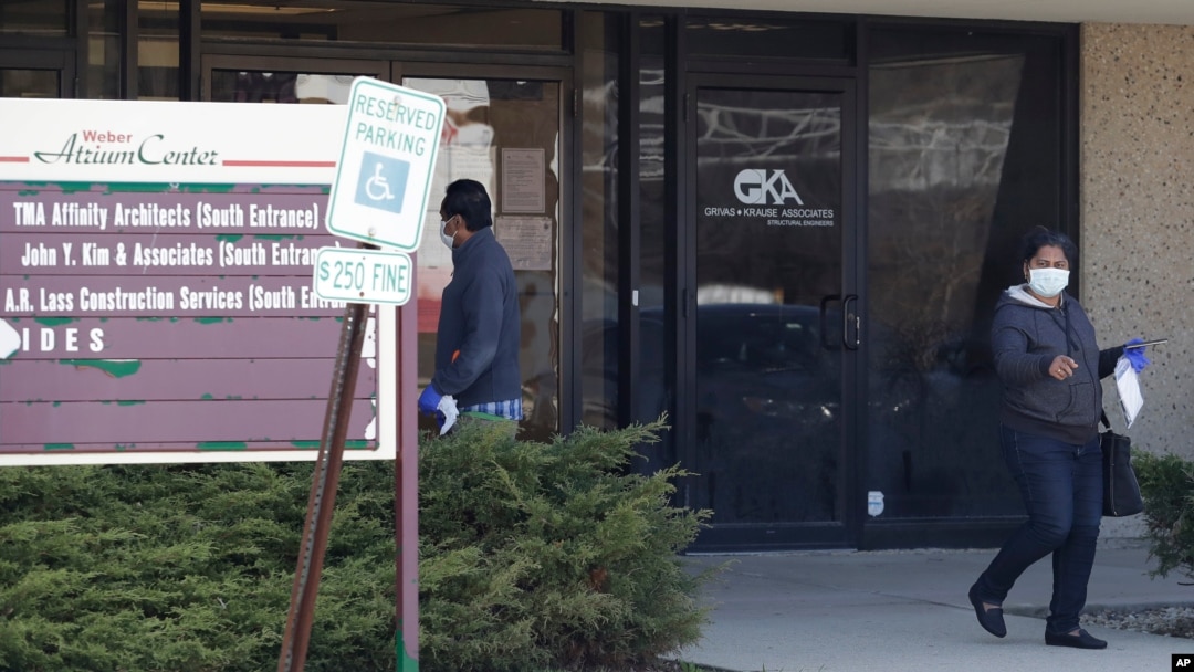 A woman leaves after checking job application information in front of IDES (Illinois Department of Employment Security) WorkNet center in Arlington Heights, Ill., Thursday, April 9, 2020. 