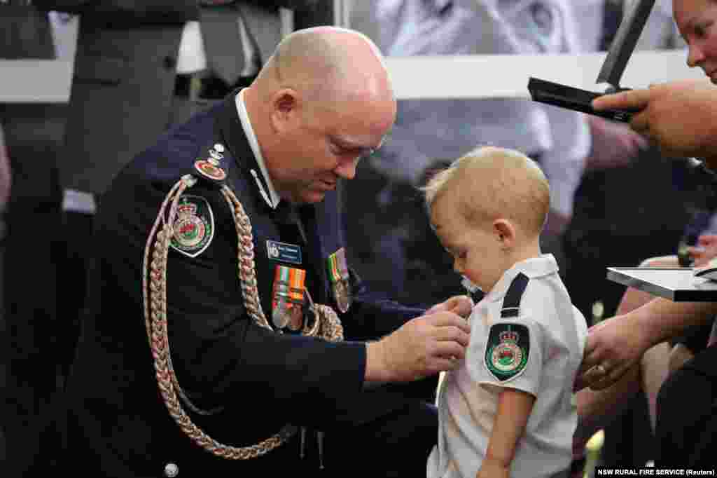 RFS Commissioner Shane Fitzsimmons presents a posthumous Commendation for Bravery and Service to the son of volunteer firefighter Geoffrey Keaton at Keaton&#39;s funeral in Buxton, New South Wales, Australia, in this picture obtained from social media. Keaton was killed by wildfires in recent weeks.