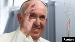 Pope Francis smiles onboard the papal plane during his return to Rome, from Asuncion, Paraguay, July 13, 2015.