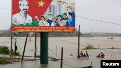 Người dân tìm cách đưa xe máy ra khỏi khu vực bị ngập nước trong bão số 10 tại tỉnh Hà Tĩnh, ngày 15/9/2017.