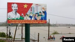 Warga menyelamatkan sepeda motor dari ladang-ladang yang terendam banjir saat Topan Doksuri melanda provinsi Ha Tinh, Vietnam, 15 September 2017. 