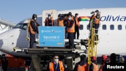 Trabajadores descargan contenedores de la vacuna rusa Sputnik 5 para COVID-19 en el Aeropuerto Internacional de El Alto, Bolivia, el 28 de enero de 2021.