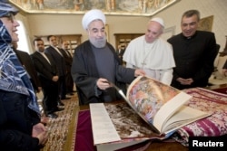 Iran President Hassan Rouhani, left, exchanges gifts with Pope Francis at the Vatican, Jan. /26, 2016.