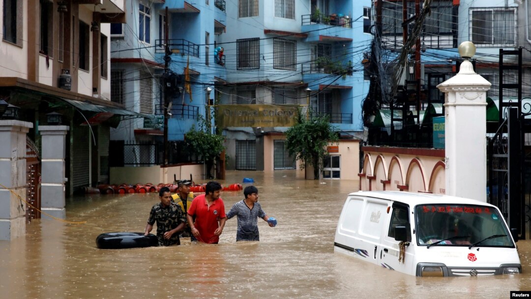 Warga berjalan di kawasan yang tergenang banjir di Kathmandu, Nepal, 12 Juli 2019. (Foto: dok).