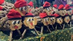 El “tió, estos tronco de árbol decorado con una barretina roja y tapado con una manta, es otra de las tradiciones más destacadas durante la navidad española. Foto: VOA.