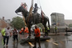 Workers remove the statue of Confederate General Stonewall Jackson from it's pedestal on Monument Avenue, July 1, 2020, in Richmond, Virginia.