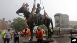 Workers remove the statue of Confederate General Stonewall Jackson from it's pedestal on Monument Avenue, July 1, 2020, in Richmond, Virginia.