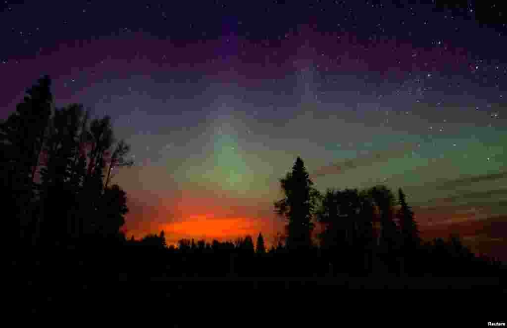 The wildfires glow underneath the Northern Lights, also known as the Aurora Borealis, near Fort McMurray, Alberta, Canada, May 7, 2016.