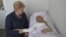 Lithuania's President Dalia Grybauskaite (L) holds the hand of jailed Ukrainian opposition leader Yulia Tymoshenko during her visit to a hospital, in Kharkiv, Ukraine, May 11, 2012.
