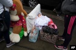 Neighbors organize their belongings on the sidewalk as they collect items from their earthquake-damaged building in the Ciudad Jardin neighborhood of Mexico City, Sept. 21, 2017.