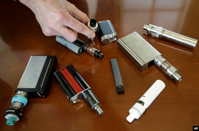 In this Tuesday, April 10, 2018 photo, vaping devices that were confiscated from students in such places as restrooms or hallways at the school in Marshfield, Mass.