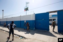 FILE - A Brazilian U.N. peacekeeper opens a gate at the U.N. base in the Cite Soleil slum of Port-au-Prince, Haiti.