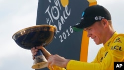 Juara Tour de France 2016 Chris Froome dari Inggris memegang pialanya di Paris (24/7). (AP/Christophe Ena)