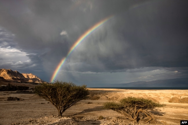 A rainbow is pictured above the Dead Sea near near Kibbutz Ein Gedi in eastern Israel on December 30, 2024. The Dead Sea, nestled where Israeli, Jordanian and Palestinian territory meet, has famously been dying for years. (Photo by Menahem Kahana / AFP)